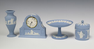 A collection of Wedgwood blue Jasperware including a jar and cover 8cm, vase 15cm, comport 15cm and a mantel timepiece 13cm 