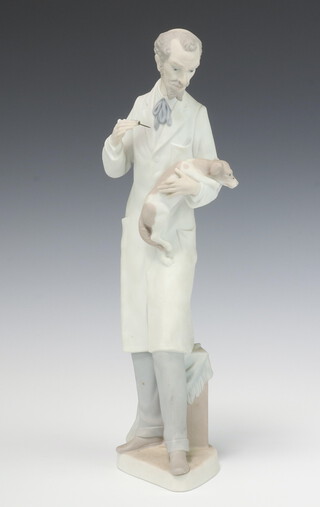 A Lladro figure of a standing veterinary surgeon with dog, the base impressed 10, 34cm 