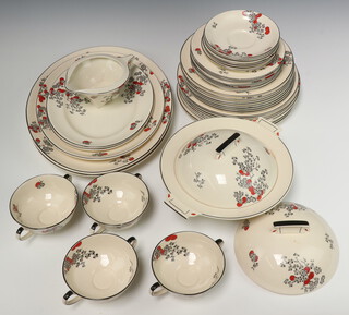 A 41 piece Royal Doulton Carnival pattern dinner service comprising twin handled tureen (some crazing) and lid, 5 meat plates 2 x 39cm, 1 x 33cm, 2 x 27cm, sauce boat, 8 dinner plates 26cm (1 with chip and all with contact marks) 8 breakfast plates 24cm, 8 side plates 19cm (5 cracked), 4 twin handled soup bowls (cracked and 1 with a chip) 5 twin handled bowls (1 crazed, 1 chipped), 6 saucers 