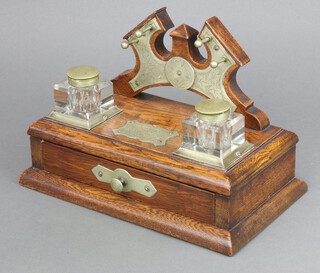 An Edwardian oak and silver plated standish the raised back with pen rack and 2 square cut glass inkwells (1 with large chip, the other chips in places), the base fitted a drawer and with presentation plaque marked Kinnoull Rec Club Presidents Prize Won By Mr M Henry, 1911