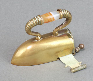 A Victorian novelty gilt metal tape measure in the form of a flat iron with a polished hardstone grip 5cm x 5cm x 2cm 