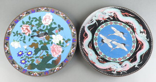 A black ground cloisonne charger decorated dragons and storks 37cm (light contact marks) together with a blue floral patterned ditto decorated a bird 30cm diam. 