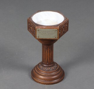 An Edwardian hexagonal carved oak table top font with turned and fluted column, spreading foot, 32cm h x 19cm w x 17cm d, with inscription plaque "In loving memory of William Campinot, died March 1907" (liner missing) 