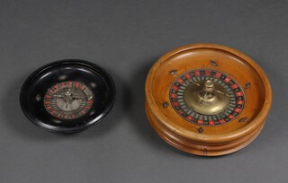 A turned beech and metal roulette wheel 9cm x 32cm (some rubbing to numbers) together with an ebonised ditto 6cm x 24cm (numbers missing in places) 