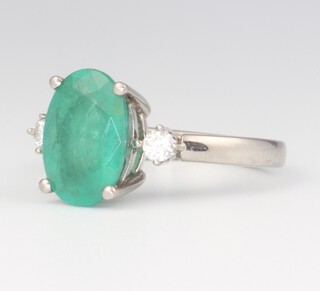 A platinum dress ring set an oval cut emerald supported by 2 diamonds, size O, 
gross weight 6.1g