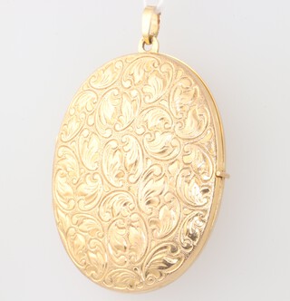 An oval yellow metal engraved double photo locket 4cm, 8 grams 