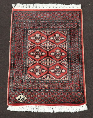 A pink ground Persian carpet, the rectangular central medallion with 6 stylised medallions to the centre 90cm x 68cm, signed to one corner 