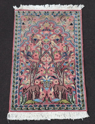 A pink ground and floral patterned Persian prayer rug 92cm x 58cm 