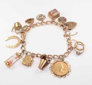 A 9ct gold curb link charm bracelet hung a Elizabeth II 1965 sovereign and 12 other charms, gross weight 47.5 grams 