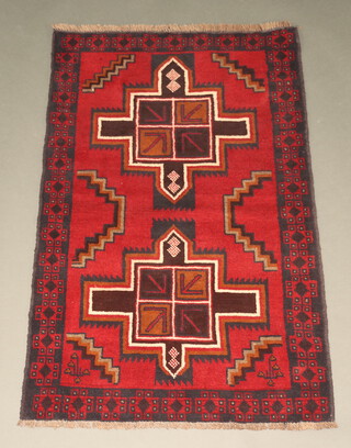 A red, black and white ground Belouche rug with 2 medallions to the centre 136cm x 87cm 
