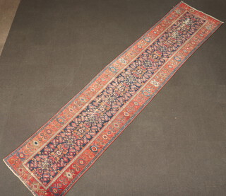 A red, blue and white ground Caucasian style runner with central floral medallion contained within a 3 row border 470cm x 103cm  