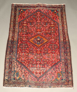 An orange, red and blue ground Persian rug with diamond medallion to the centre 173cm x 109cm 