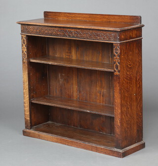 A 1920's carved oak bookcase with raised back fitted adjustable shelves, raised on a platform base 90cm h x 91cm w x 27cm d 