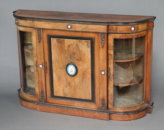 A Victorian figured walnut and ebonised credenza, the centre enclosed by a panelled door flanked by cupboards enclosed by arched glazed panelled doors, having gilt metal embellishments and floral porcelain panels 97cm h x 148cm w x 39cm d 