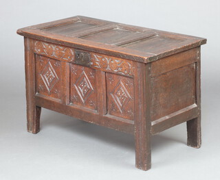 A 17th/18th Century coffer of carved panelled construction with original ring rings, the interior fitted a candle box with metal lock front 58cm h x 90cm w x 48cm d 