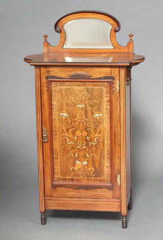 An Edwardian heavily inlaid mahogany music cabinet with raised arched mirrored back, fitted shelves enclosed by panelled door 123cm h x 72cm w x 37cm d 