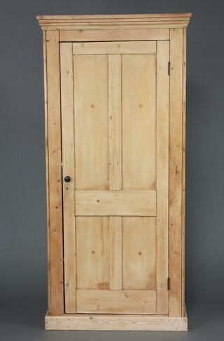 A Victorian pine wardrobe with moulded cornice, fitted a shelf and hanging space above a recess, enclosed by a panelled door, raised on a platform base 209cm h x 99cm w x 51cm d (in one section) 