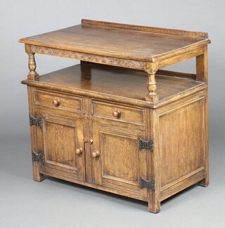 A 1930's bleached oak buffet with raised back above recess, base fitted 2 drawers above cupboard enclosed by panelled doors 85cm h x 91cm w x 51cm d  