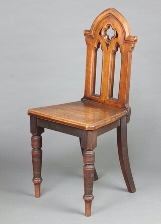 A Victorian bleached mahogany Gothic hall chair with pierced back, solid seat, raised on turned supports 90cm h x 44cm w x 36cmd 