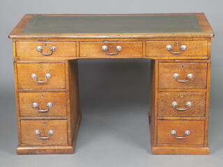 A Victorian oak desk with green leather writing surface above 1 long and 8 short drawers 82cm h x 130cm w x 72cm d 