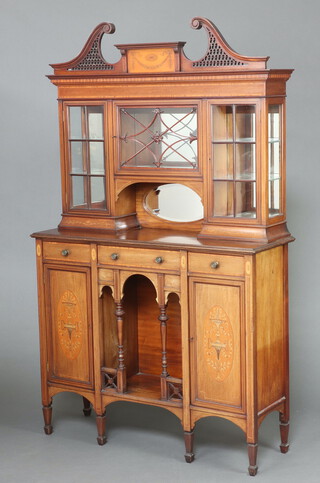 An Edwardian inlaid mahogany display cabinet with pierced broken pediment, the upper section fitted 3 cupboards with mirrored back enclosed by astragal glazed panelled door above a recess, the base fitted 1 long and 2 short drawers with recess flanked by cupboards enclosed by panelled doors 201cm h x 121cm w x 39cm d 