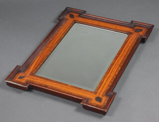 A Victorian beveled plate mirror contained in a mahogany and crossbanded frame  with mitred corners each decorated a fleur de lis 80cm h x 60cm w 