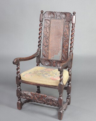 A Charles II carved walnut open arm chair with cane panel to the back, raised on turned and block supports with carved H framed stretcher to the front 114cm h x 57cm w x 49cm d (seat 22cm x 24cm)  