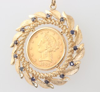 An American 1897 5 dollar coin set in a yellow metal pendant mount with sapphires, gross weight 20.8 grams 