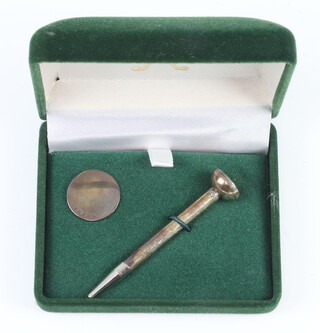 A silver golf tee and ball marker, cased
