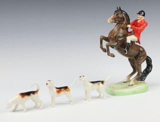 A Beswick figure of a huntsman on rearing horse, second version, brown gloss no.868, 22cm, modelled by Arthur Gredington  together with 3 hounds 