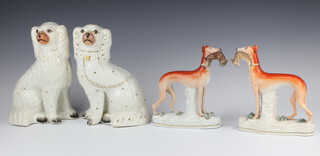 A pair of Victorian Staffordshire figures of hounds holding hares 20cm and 2 Staffordshire Spaniels 24cm and 25cm 