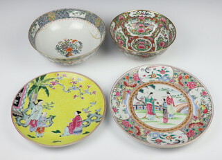 A 20th Century famille rose style punch bowl decorated with panels of flowers and insects 22cm, a 19th Century bowl decorated with flowers and motifs 25cm, a yellow ground plate 28cm and a famille rose plate 31cm 