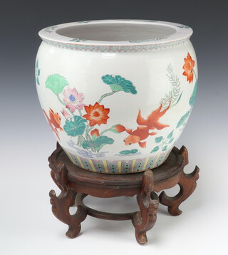 A 20th Century Chinese jardiniere decorated with carp 31cm on a hardwood stand 