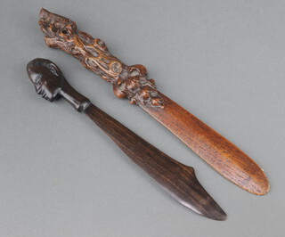 A Victorian carved oak paperknife the carved and pierced terminal decorated a squirrel 31cm (tail f) together with an African ditto with portrait bust to the terminal 24cm (chip to base) 