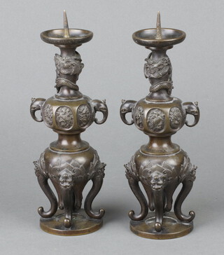 A pair of 19th Century Japanese bronze twin handled urns with scroll supports, the base with 3 character signature 20cm x 15cm