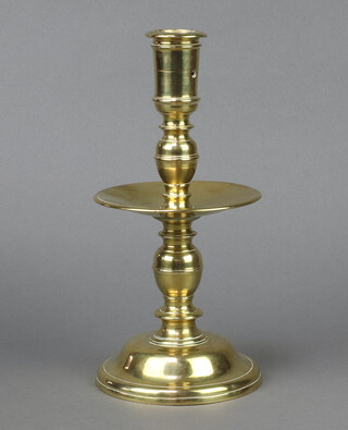 A mid 17th century "Heemskerk" brass candlestick with pierced socket supported by ridge ball knop above circular drip tray, raised on a domed base 27cm h x 12cm d 