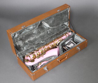 A pink and gilt metal alto saxophone, contained in a light brown leather fitted hard case.