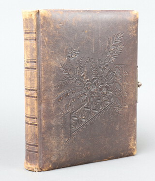 A Victorian photograph album bound in full brown Morocco with tooled decoration to the front board, locking clasp to book block, 4to. (the album is empty)