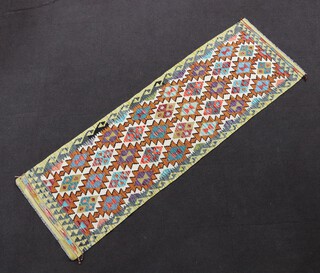 A white, tan, turquoise and green ground Chobi Kilim runner with overall geometric design 255cm x 82cm  