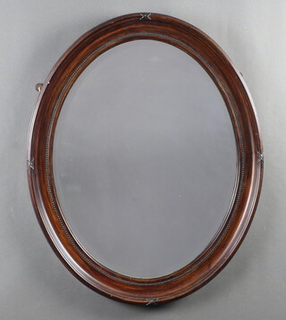 An Edwardian oval bevelled plate wall mirror contained in a mahogany effect ribbon frame 72cm x 57cm 