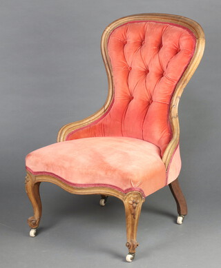 A Victorian bleached mahogany show frame nursing chair upholstered in pink buttoned material, on cabriole supports 88cm h x 56cm w x 50cm d (frame loose, crack to the right hand side, upholstery has moth and water damage in places)