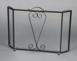 A wrought iron and plate glass fire screen 55cm h x 76cm w x 12cm d 