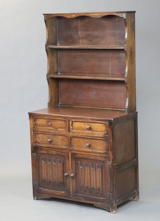 An oak dresser the raised back fitted 2 shelves above 2 short and 1 long  drawer above a cupboard enclosed by linenfold panelled door 177cm h x 92cm w x 46cm d (handle missing to top left hand drawer) 