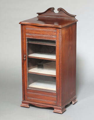 An Edwardian music cabinet with shaped top, fitted shelves enclosed by glazed panelled door, raised on bracket feet 100cm h x 48cm w x 41cm d (contact marks in places)