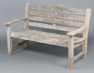 A well weathered slatted hardwood garden bench 81cm h x 138cm w x 63cm d  