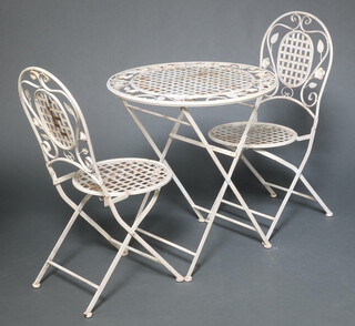 A circular pierced metal folding Bistro style table 75cm h x 69cm diam. and 2 matching folding chairs (some rust)