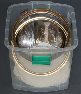 A quantity of new gilt metal clock bezels and glasses, contained in a plastic box 