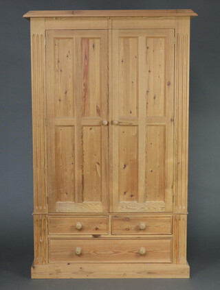 A Victorian style pine wardrobe with moulded cornice enclosed by panelled doors, the base fitted 4 short drawers 189cm h x 118cm w x 63cm d 