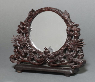 A circular plate mirror contained in a Chinese style pierced carved hardwood frame 28cm x 33cm x 8cm 