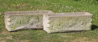 A pair of well weathered garden trough shaped planters with cast flower mask decoration 26cm h x 72cm w x 24cm d 